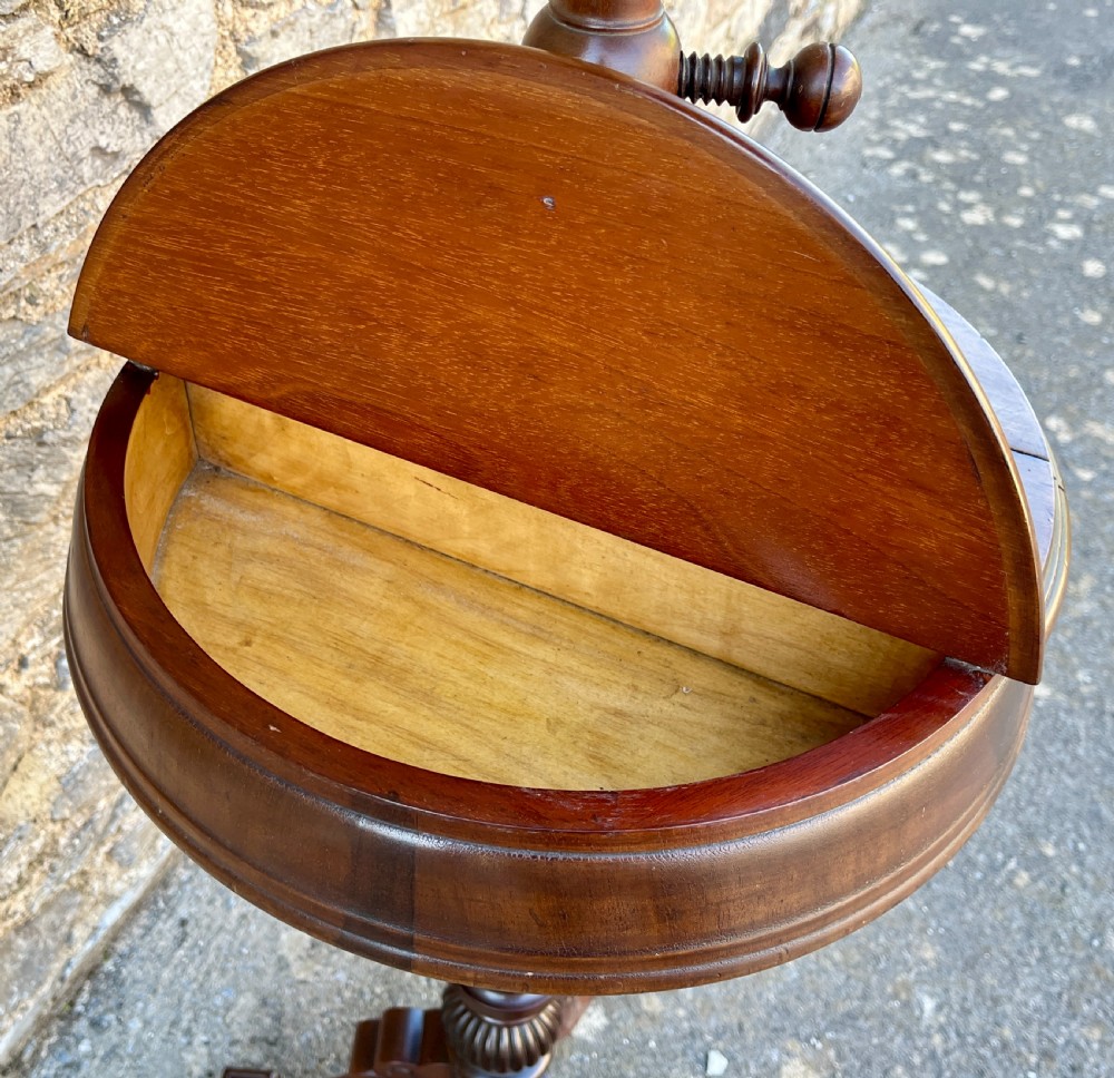 A Victorian walnut adjustable shaving stand with a circular mirror mounted on a brass stem above a small circular tabletop and turned pedestal tripod base. View VI