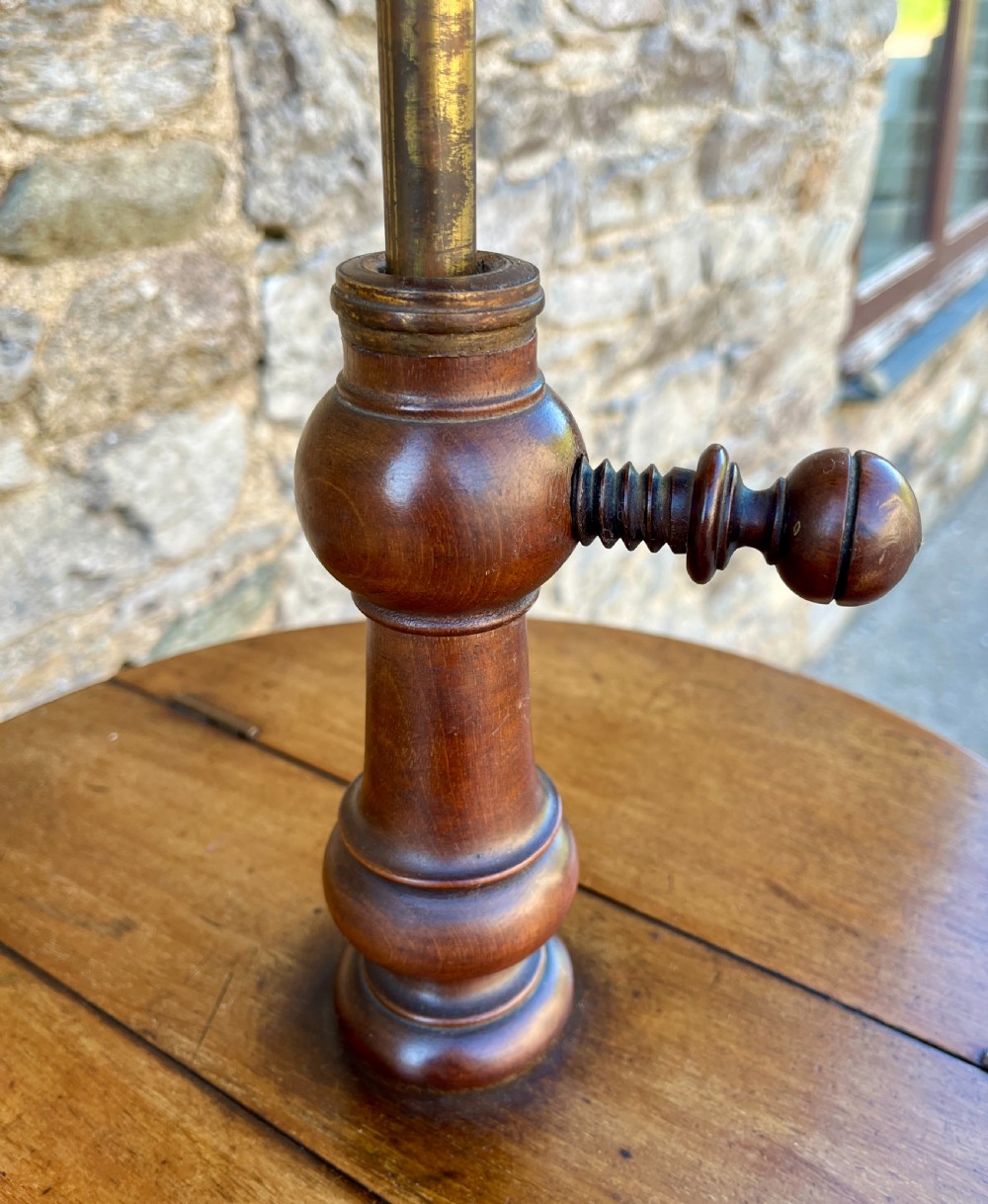 A Victorian walnut adjustable shaving stand with a circular mirror mounted on a brass stem above a small circular tabletop and turned pedestal tripod base. View VII