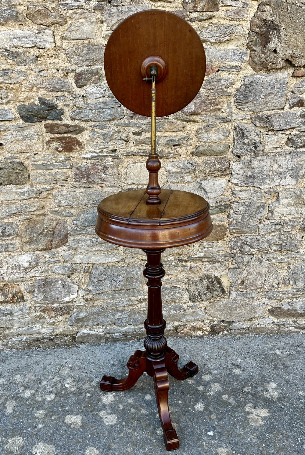 A Victorian walnut adjustable shaving stand with a circular mirror mounted on a brass stem above a small circular tabletop and turned pedestal tripod base. View IX
