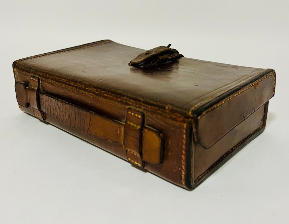 An open Victorian brown leather apothecary case revealing fitted compartments containing glass medicine bottles with stoppers and small metal tins. View VII