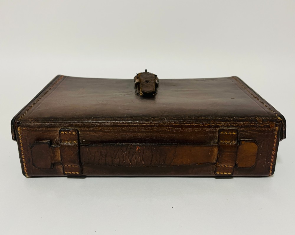 An open Victorian brown leather apothecary case revealing fitted compartments containing glass medicine bottles with stoppers and small metal tins. View VIII