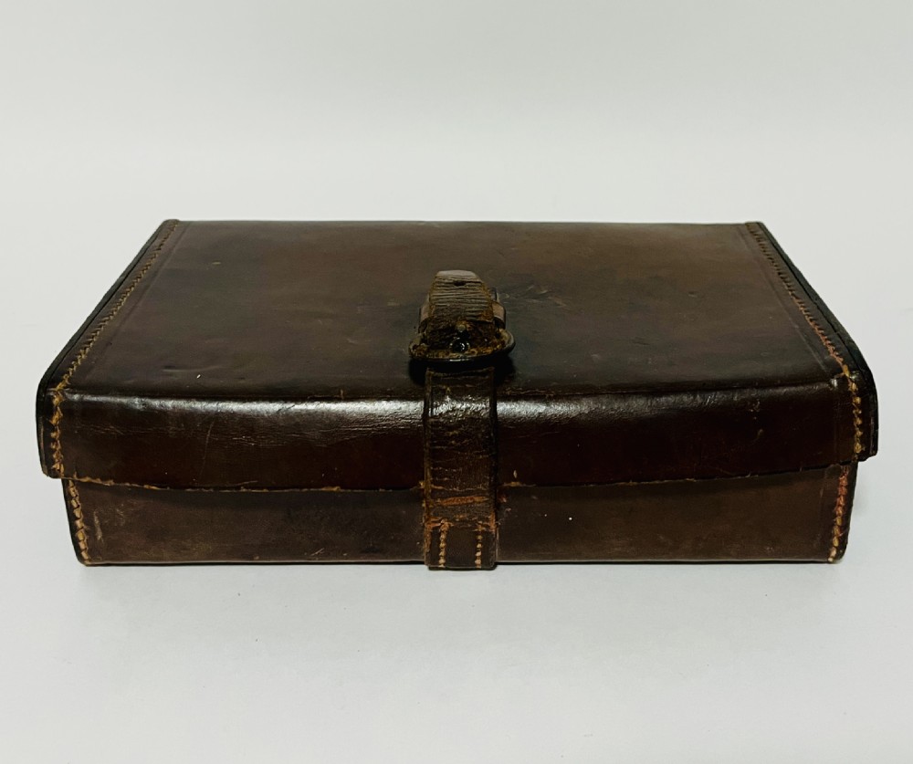 An open Victorian brown leather apothecary case revealing fitted compartments containing glass medicine bottles with stoppers and small metal tins. View XI