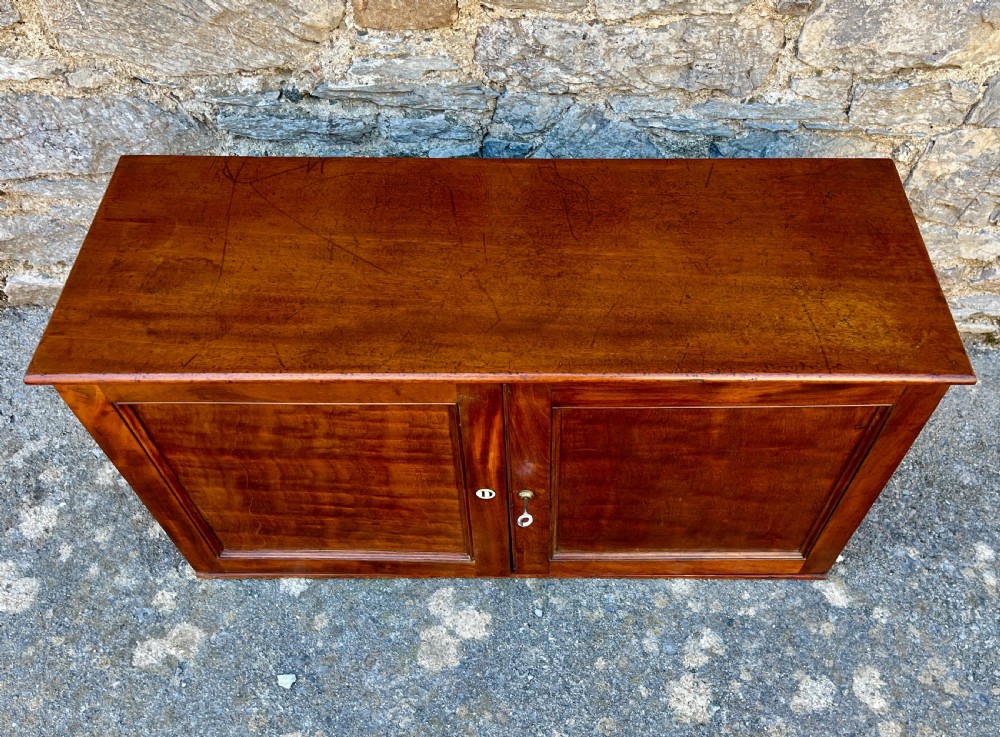 A low Victorian mahogany filing cabinet featuring twin panelled doors with flame mahogany veneer and a central keyhole. View II
