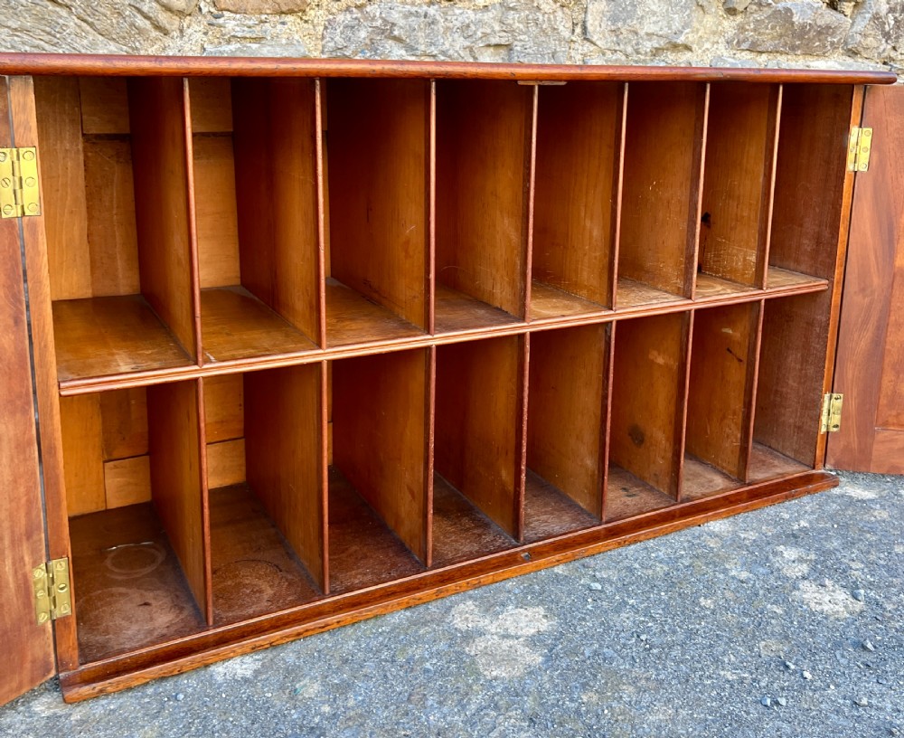 A low Victorian mahogany filing cabinet featuring twin panelled doors with flame mahogany veneer and a central keyhole. View VI