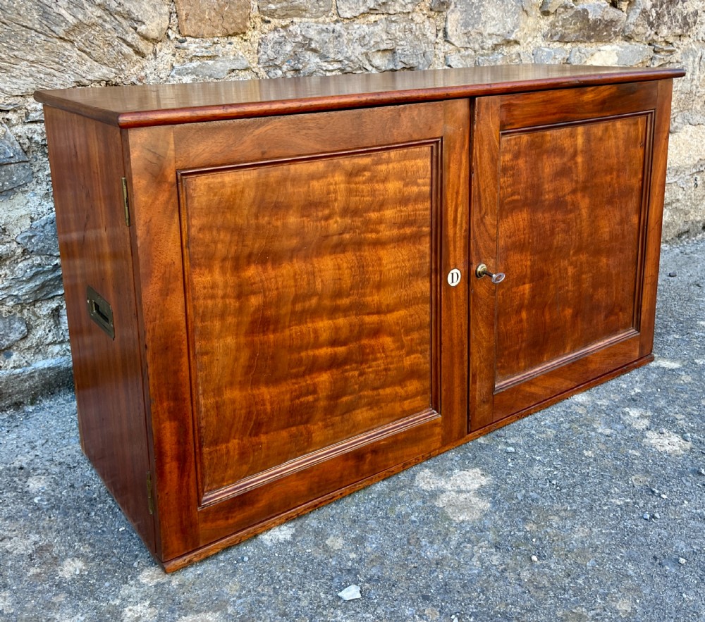 A low Victorian mahogany filing cabinet featuring twin panelled doors with flame mahogany veneer and a central keyhole. View X