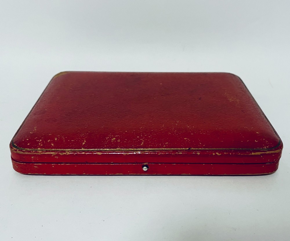 A set of six antique silver dessert knives with iridescent mother-of-pearl handles presented inside an open red velvet-lined presentation case. View VIII