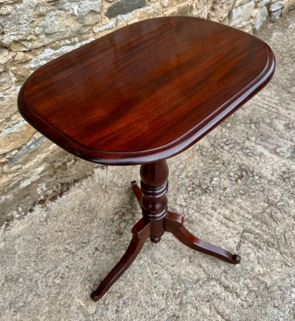 A Victorian dark mahogany wine table featuring a rounded rectangular top, a central turned baluster column, and a tripod base. View VII