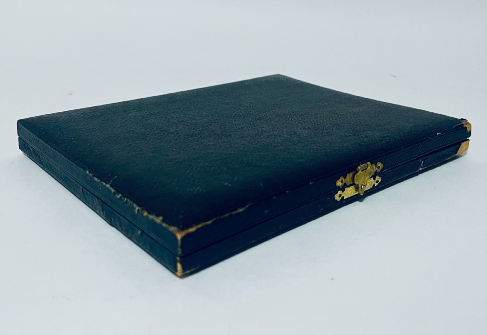 A set of six silver-handled butter knives arranged in a dark velvet and cream satin-lined presentation box. View XII