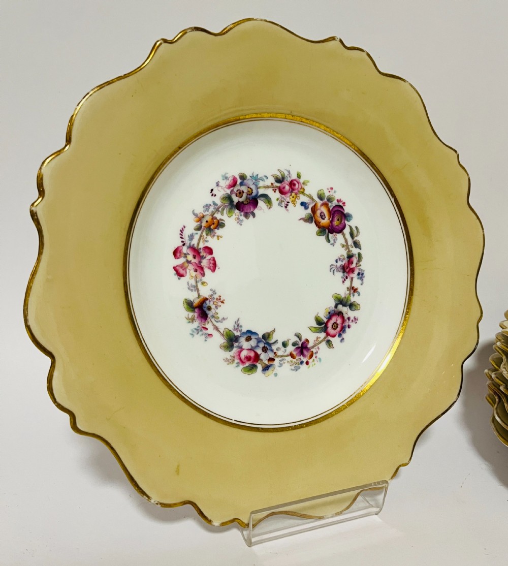 A nineteenth-century John Ridgway porcelain dessert service featuring buff-coloured borders, gilded scrollwork, reticulated handles, and hand-painted central floral garlands. View III