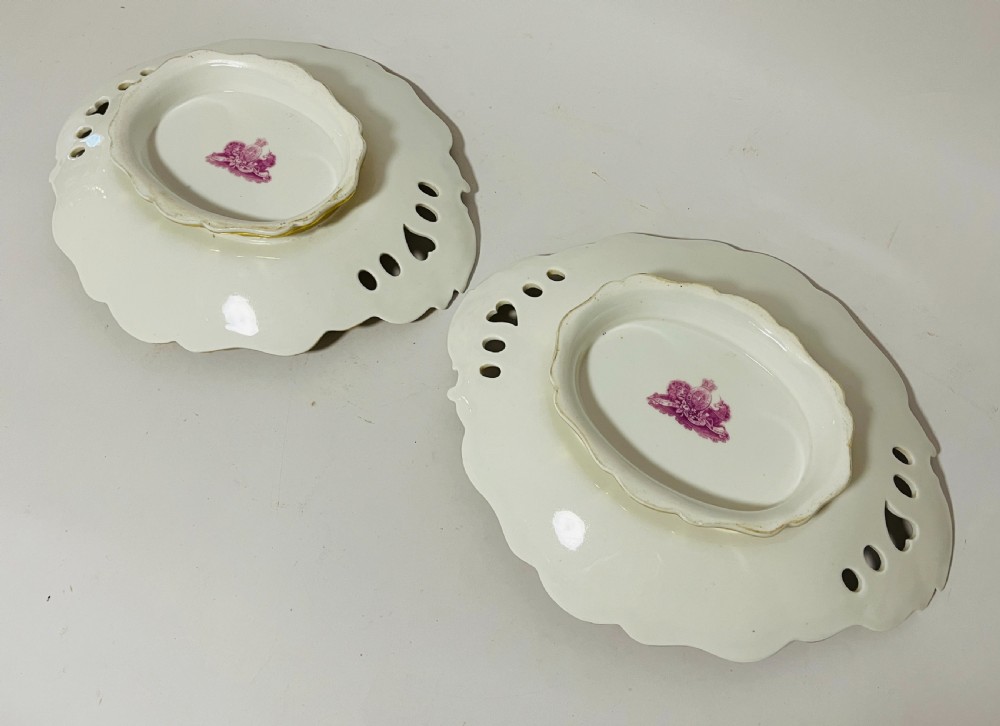 A nineteenth-century John Ridgway porcelain dessert service featuring buff-coloured borders, gilded scrollwork, reticulated handles, and hand-painted central floral garlands. View VII