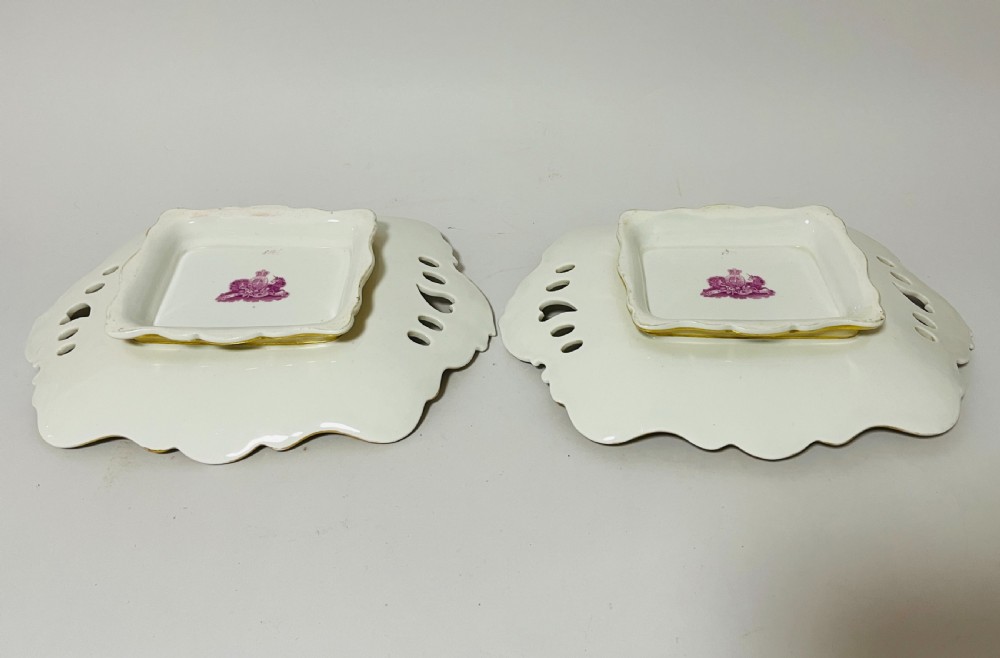 A nineteenth-century John Ridgway porcelain dessert service featuring buff-coloured borders, gilded scrollwork, reticulated handles, and hand-painted central floral garlands. View XVII