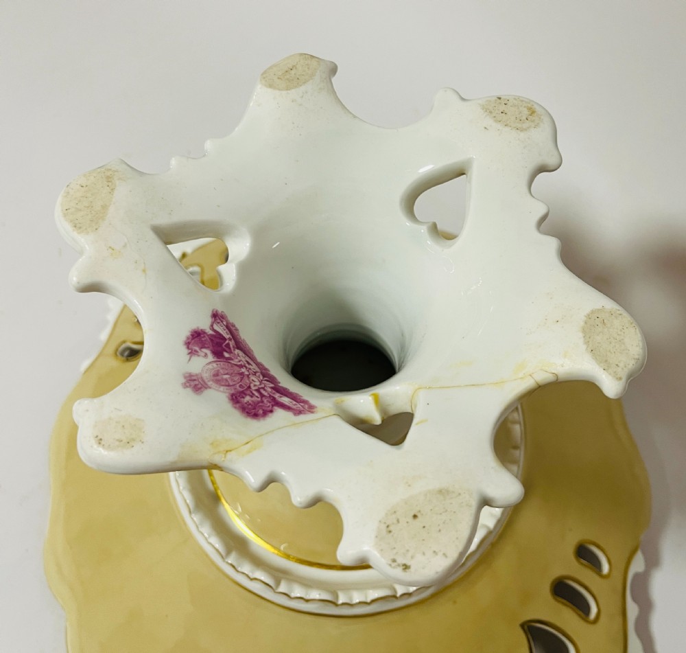 A nineteenth-century John Ridgway porcelain dessert service featuring buff-coloured borders, gilded scrollwork, reticulated handles, and hand-painted central floral garlands. View XXII