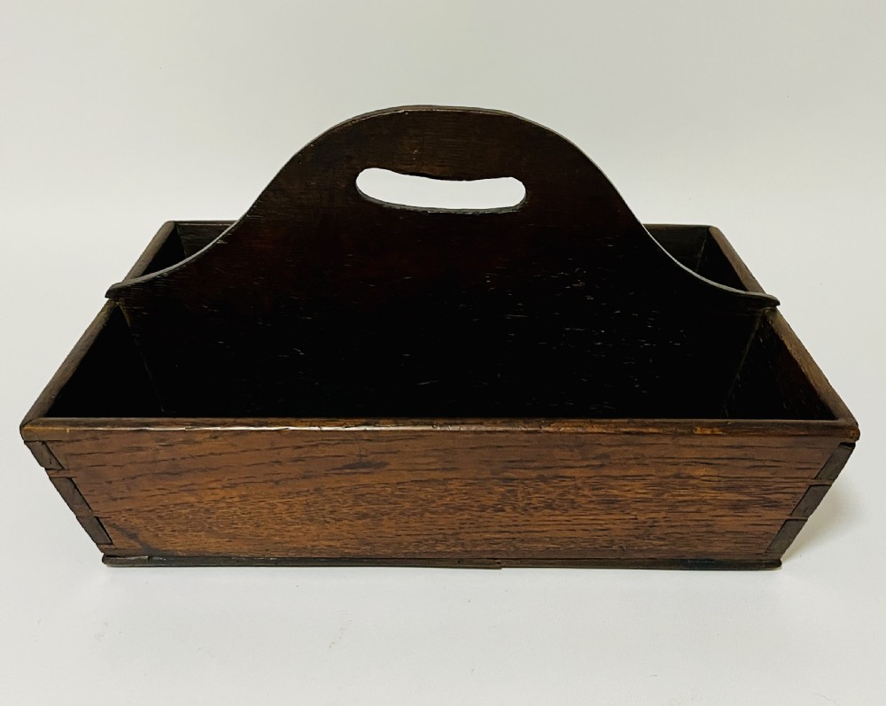 A dark brown Georgian oak cutlery tray featuring two compartments separated by a central shaped divider with a cut-out handle.