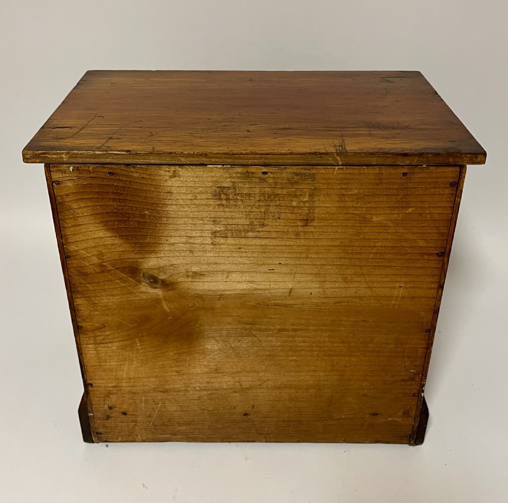 An antique stained pine specimen cabinet featuring four horizontal drawers with turned dark wood knobs and a solid plinth base. View XIII