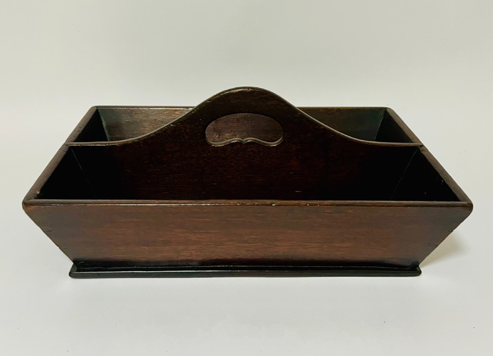 An antique Georgian dark mahogany wooden cutlery tray featuring a central division with a carved carrying handle.