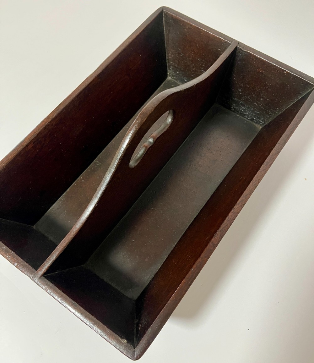 An antique Georgian dark mahogany wooden cutlery tray featuring a central division with a carved carrying handle. View V