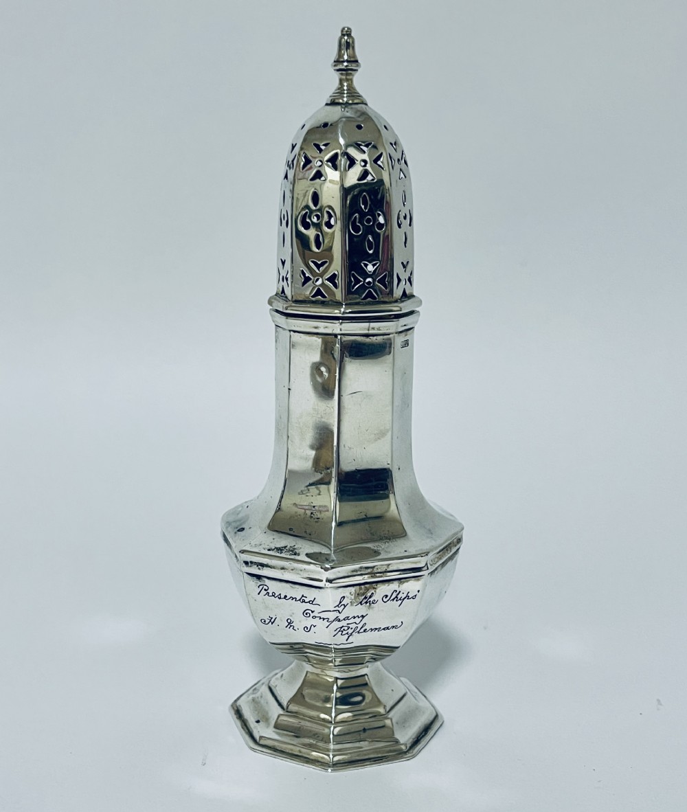 An octagonal sterling silver sugar caster featuring a hand-pierced dome cap, finial top, and engraved presentation inscription on the base.