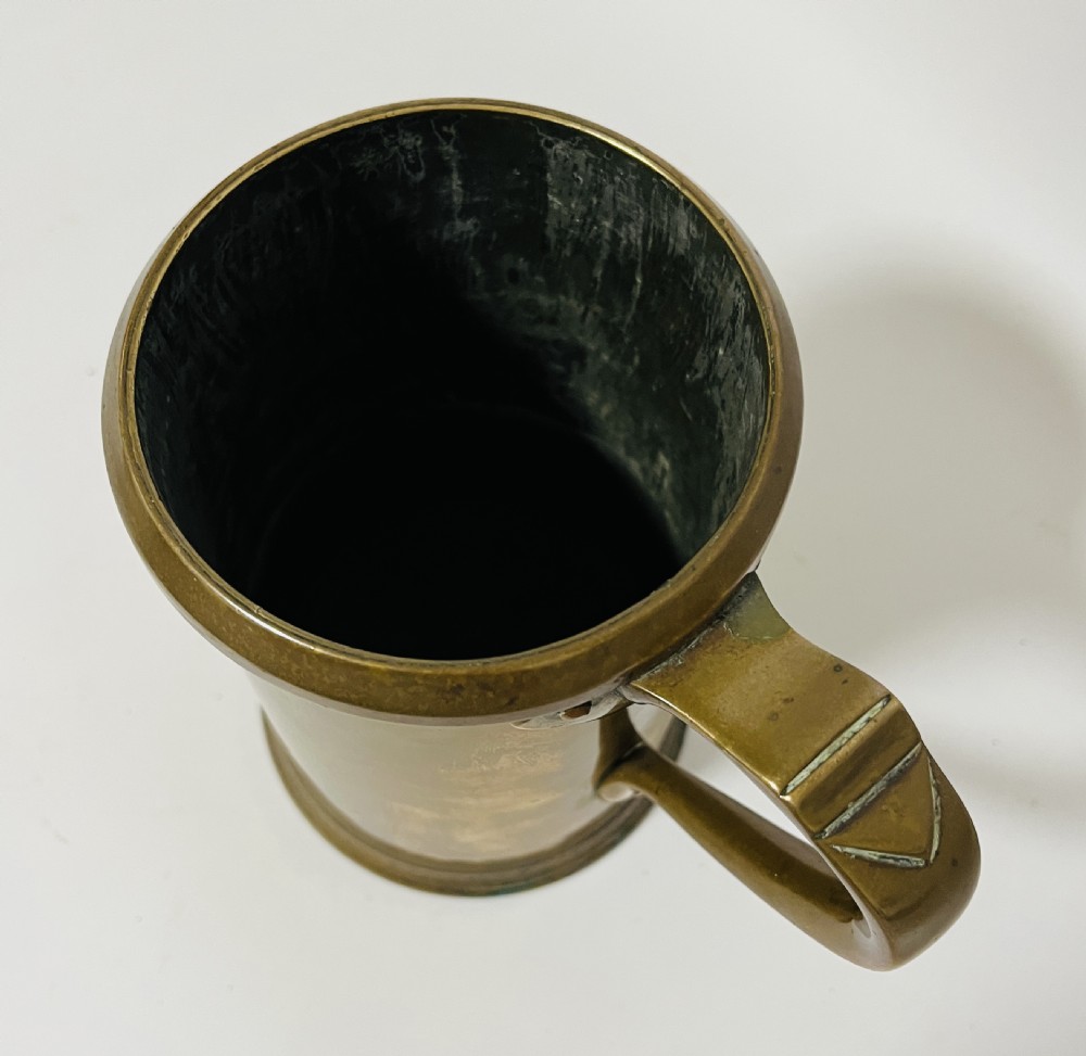 A cylindrical Victorian brass quart measure featuring a rolled rim and official stamped verification marks alongside the word QUART. View IX