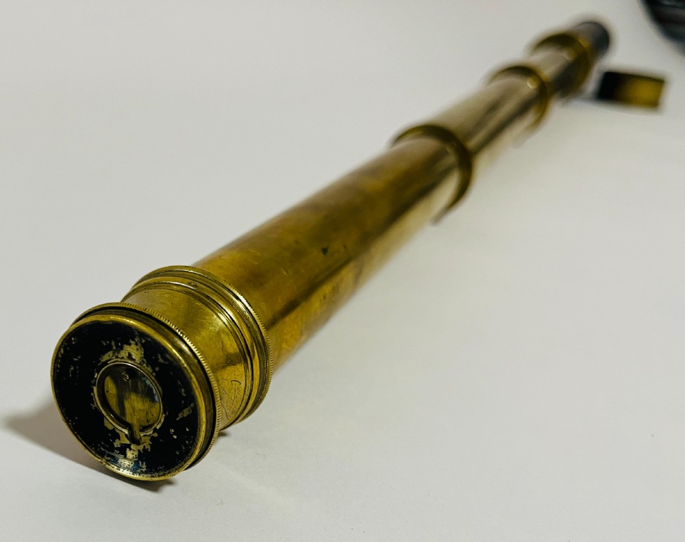 A fully extended three-draw brass telescope featuring a textured black leather sleeve around the main barrel. View IV