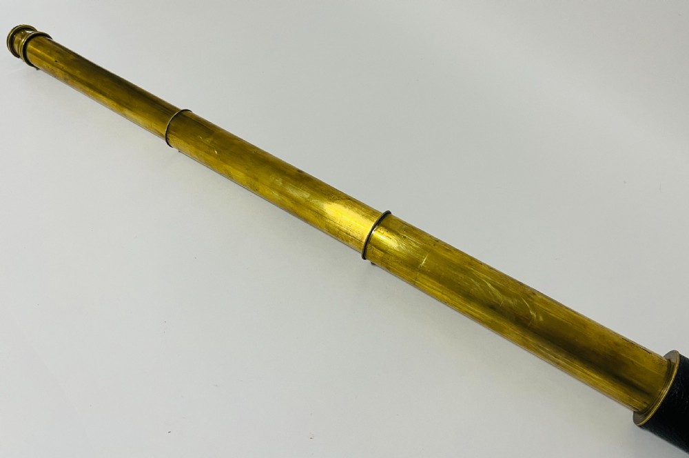 A fully extended three-draw brass telescope featuring a textured black leather sleeve around the main barrel. View IX