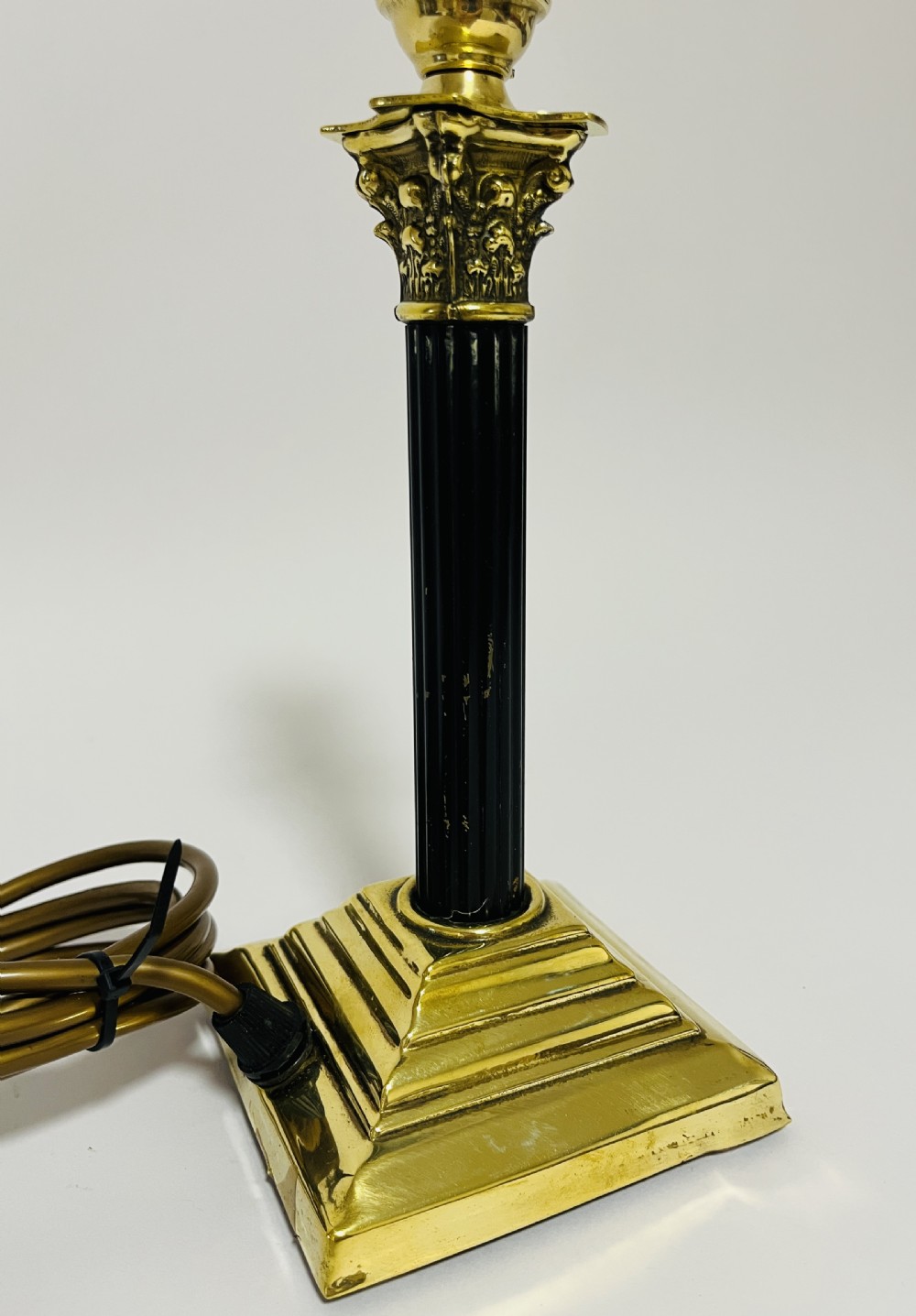 A Neoclassical Corinthian column table lamp base featuring a cast brass acanthus capital, fluted dark shaft, and stepped square brass base. View V