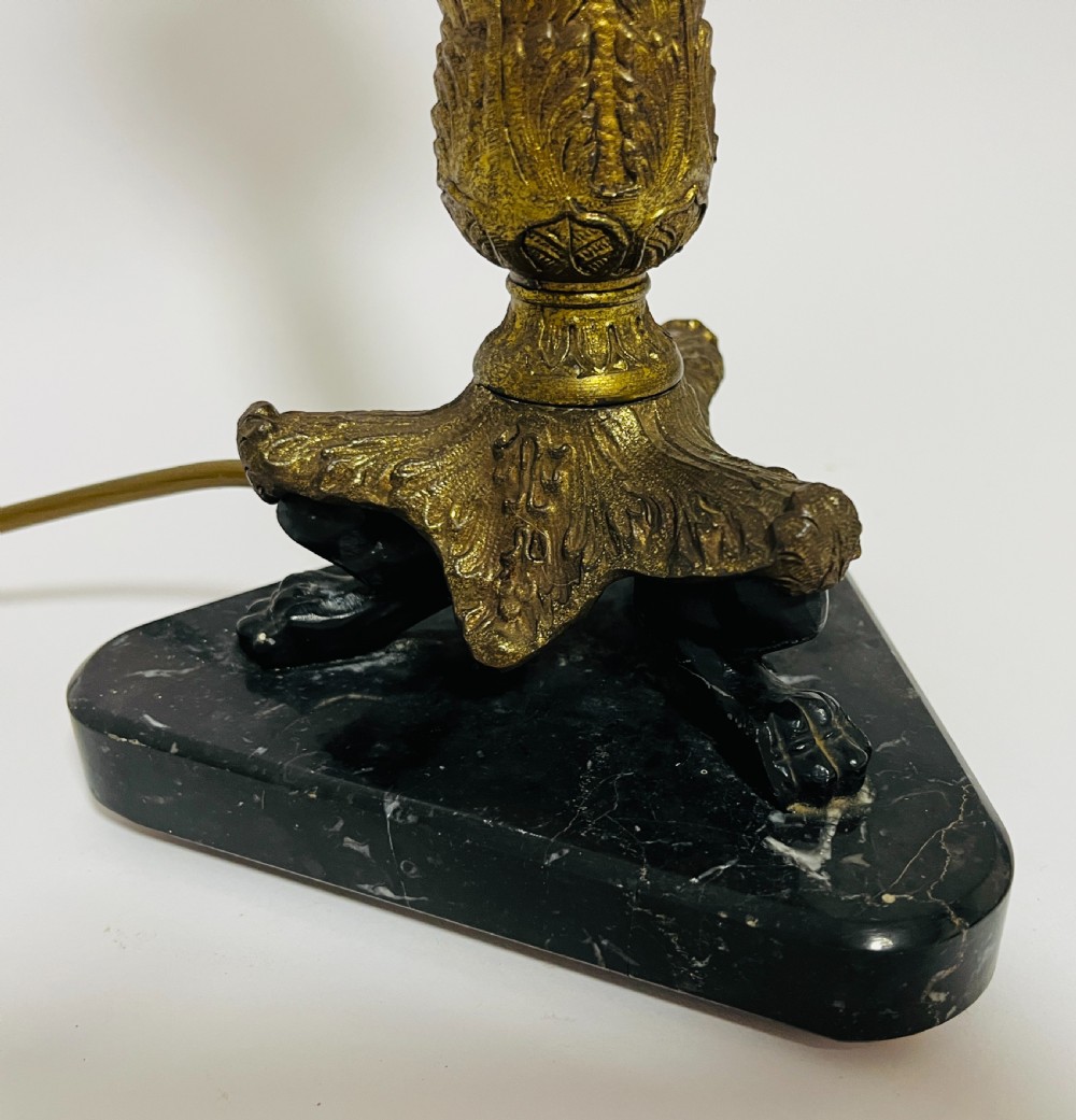 An antique French Empire table lamp featuring a gilt bronze fluted column with acanthus leaf details set upon a triangular black marble base. View XII