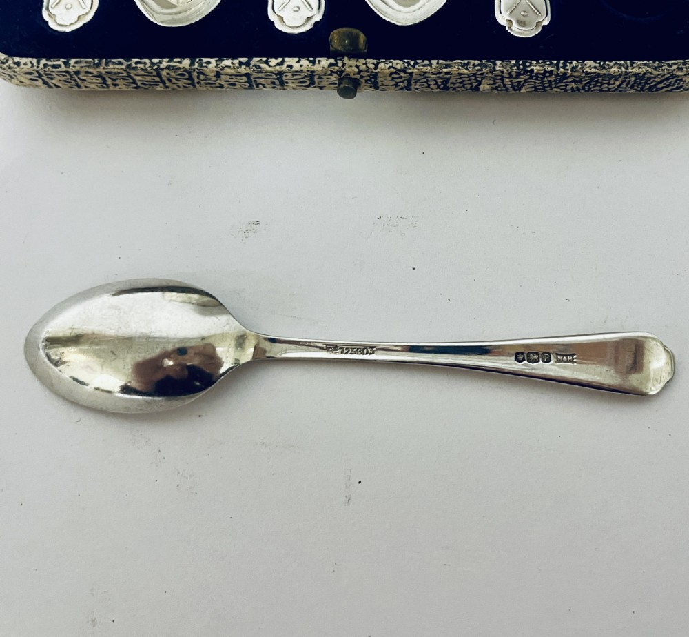 A set of six silver teaspoons with crossed golf club motifs on the handles, arranged inside an open satin and velvet lined presentation case. View VII