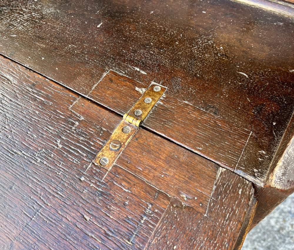 An antique dark oak Georgian bureau featuring a slant front, ornate brass escutcheons, lopers, and bracket feet. View VIII