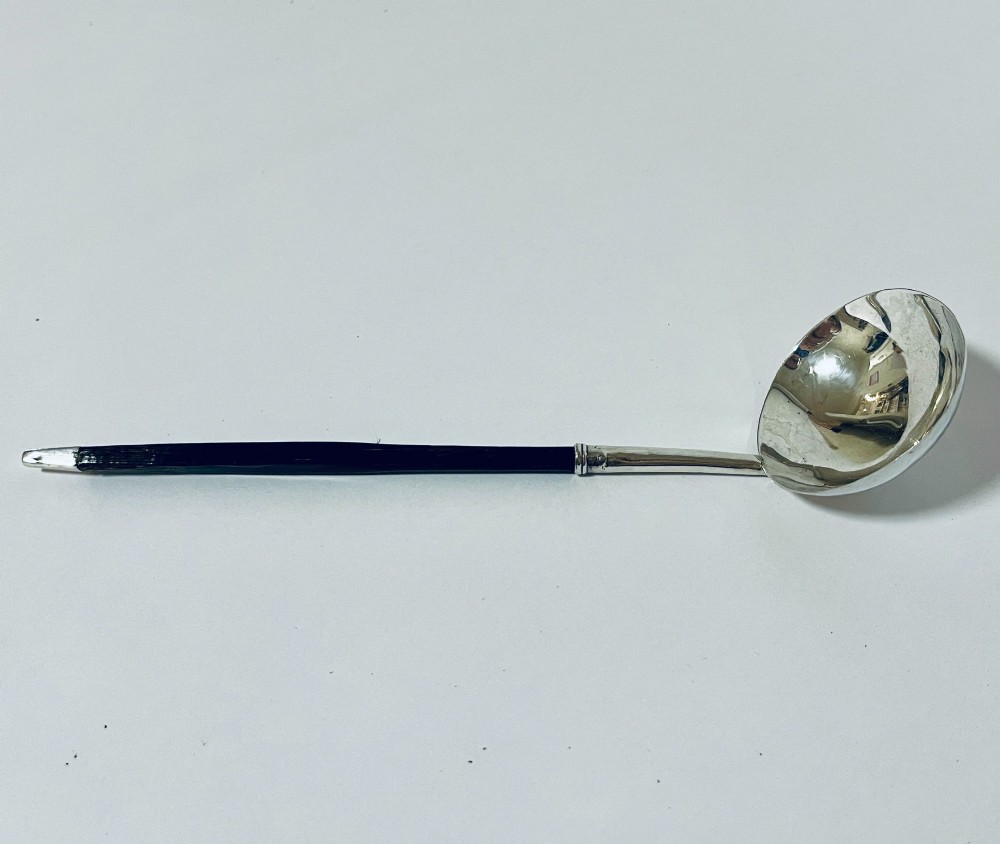 A Georgian Irish silver punch ladle with a circular polished silver bowl and a long turned dark wooden handle. View III