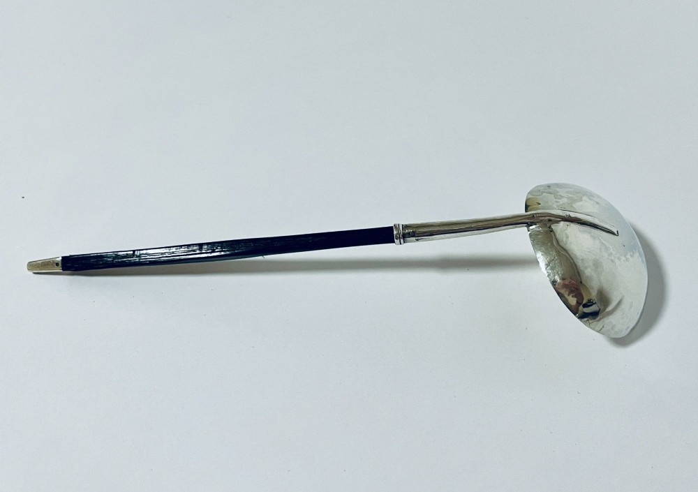 A Georgian Irish silver punch ladle with a circular polished silver bowl and a long turned dark wooden handle. View V