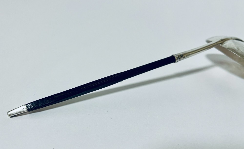 A Georgian Irish silver punch ladle with a circular polished silver bowl and a long turned dark wooden handle. View VI