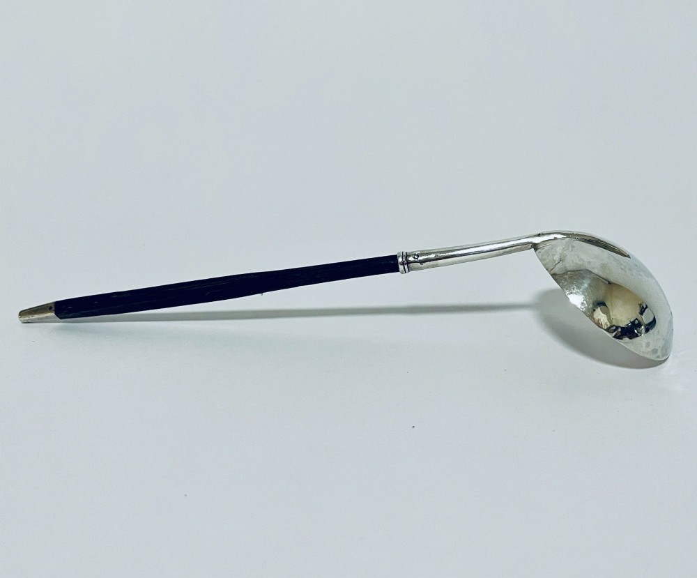 A Georgian Irish silver punch ladle with a circular polished silver bowl and a long turned dark wooden handle. View VIII