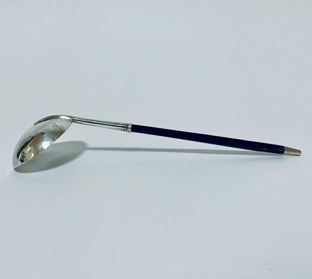 A Georgian Irish silver punch ladle with a circular polished silver bowl and a long turned dark wooden handle. View IX