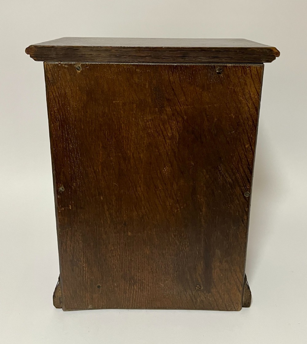 A dark oak miniature tabletop chest of drawers featuring four drawers with turned wooden knobs and a moulded plinth base. View VII