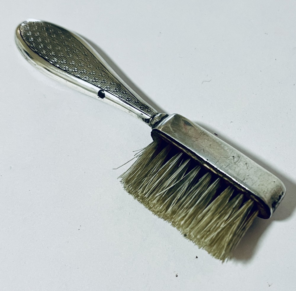An antique silver moustache brush featuring a textured handle with a central circular cartouche and visible silver hallmarks stamped on the brush head. View VIII