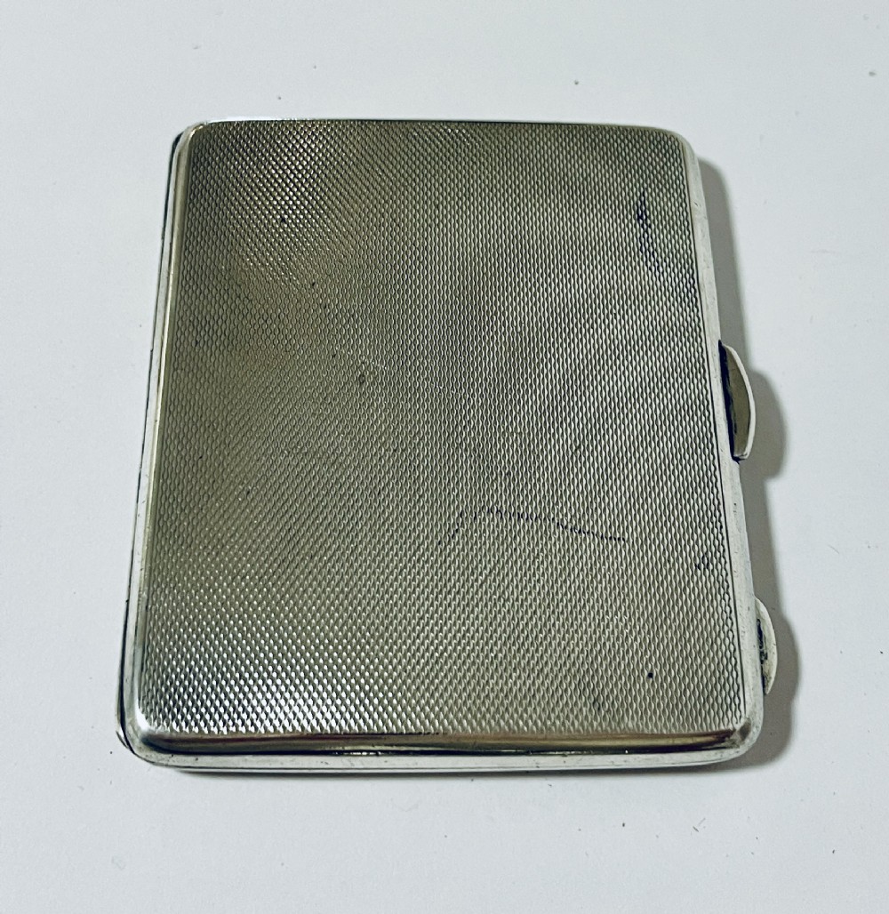 An Art Deco rectangular silver cigarette case featuring a pale yellow translucent enamel panel over a sunburst guilloche pattern. View III