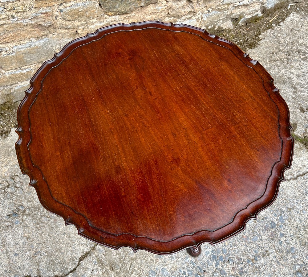 A Georgian mahogany tilt-top side table featuring a scalloped pie-crust edge, turned central column, and carved tripod cabriole legs. View VIII