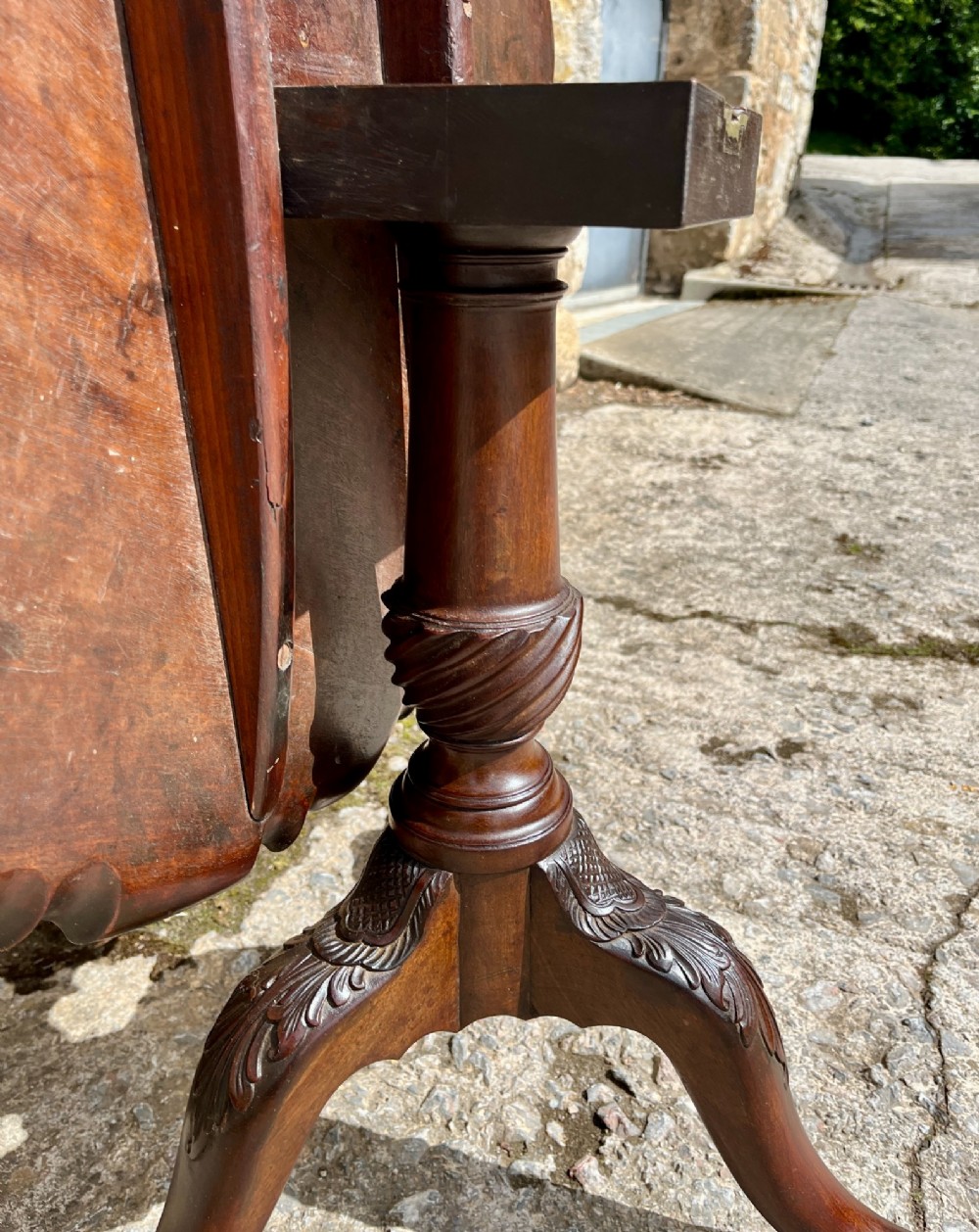 A Georgian mahogany tilt-top side table featuring a scalloped pie-crust edge, turned central column, and carved tripod cabriole legs. View XV