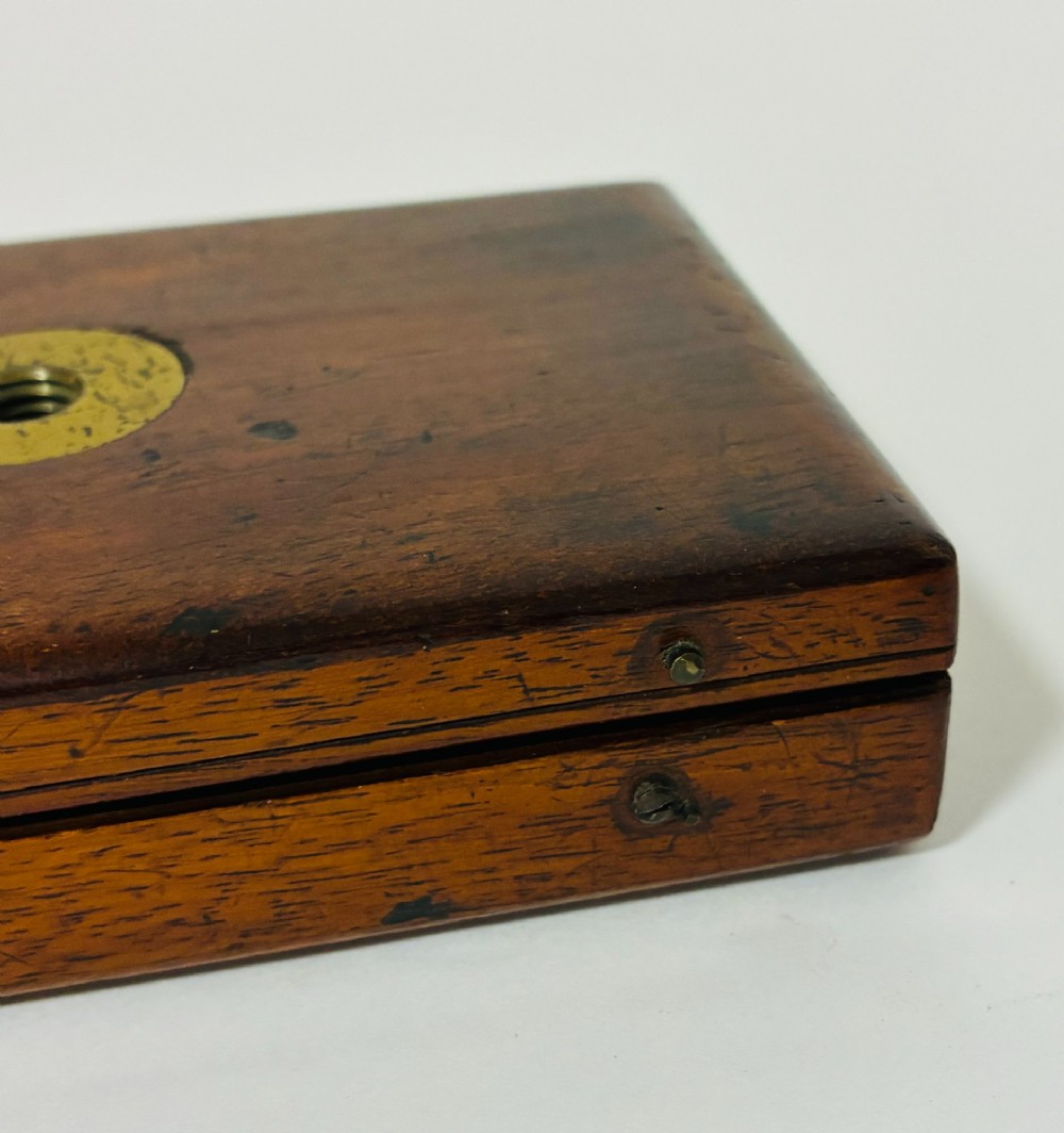 A 19th-century brass botanical field microscope mounted upright on a polished mahogany wooden storage box base. View XIV