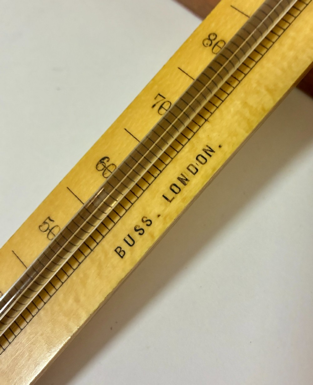 A Victorian Sikes hydrometer set resting inside an open fitted mahogany box lined with purple velvet, containing a brass float, slotted weights, and a thermometer. View IX