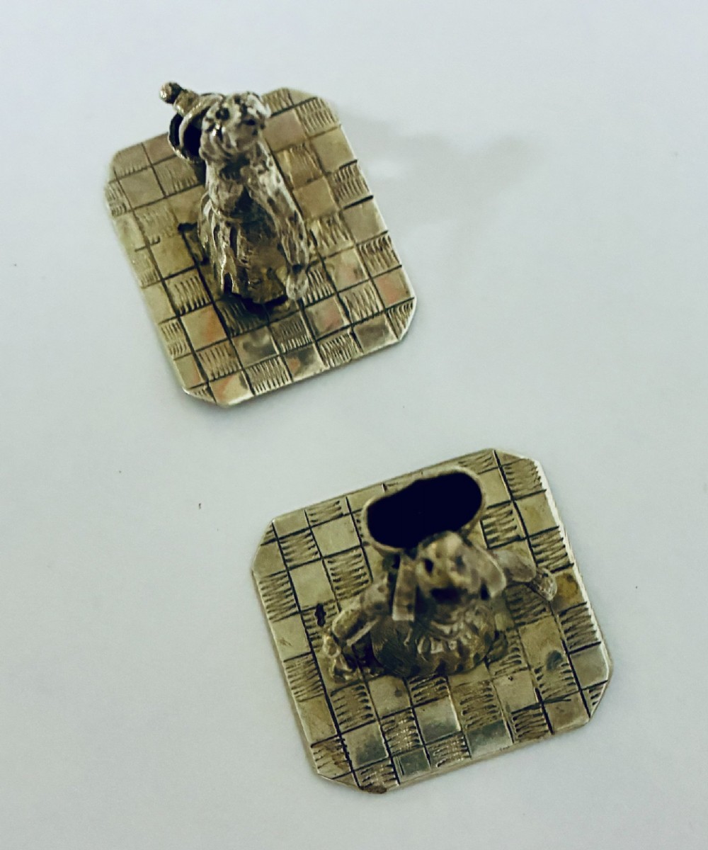 A pair of miniature silver figures depicting figures with a bucket and a walking stick on square patterned bases. View VIII