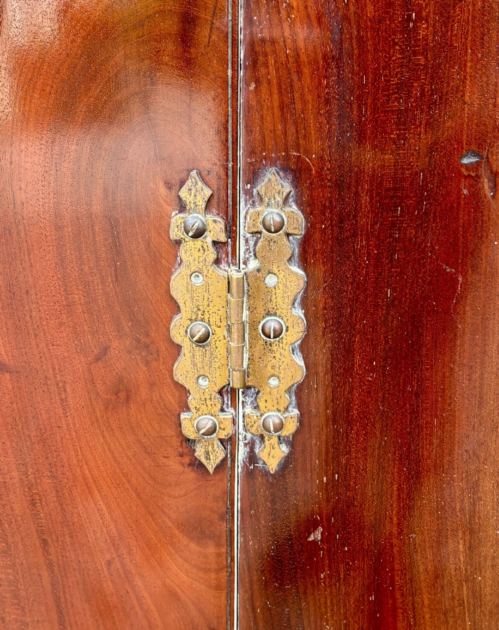 A Georgian bow-front mahogany corner cupboard featuring detailed marquetry inlays, decorative brass hinges, and central keyhole escutcheons. View VI