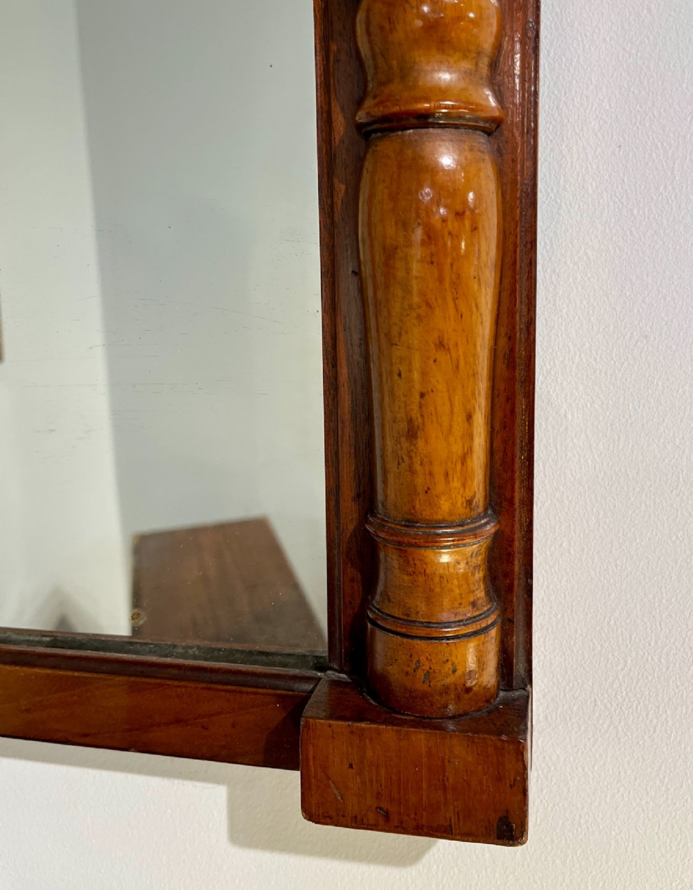 A vertical antique mahogany pier mirror featuring turned column pilasters on either side and a protruding moulded top cornice. View II