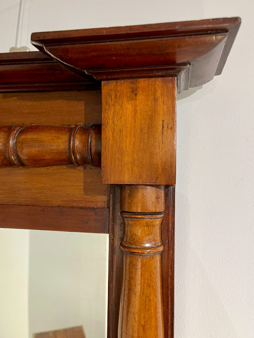 A vertical antique mahogany pier mirror featuring turned column pilasters on either side and a protruding moulded top cornice. View III