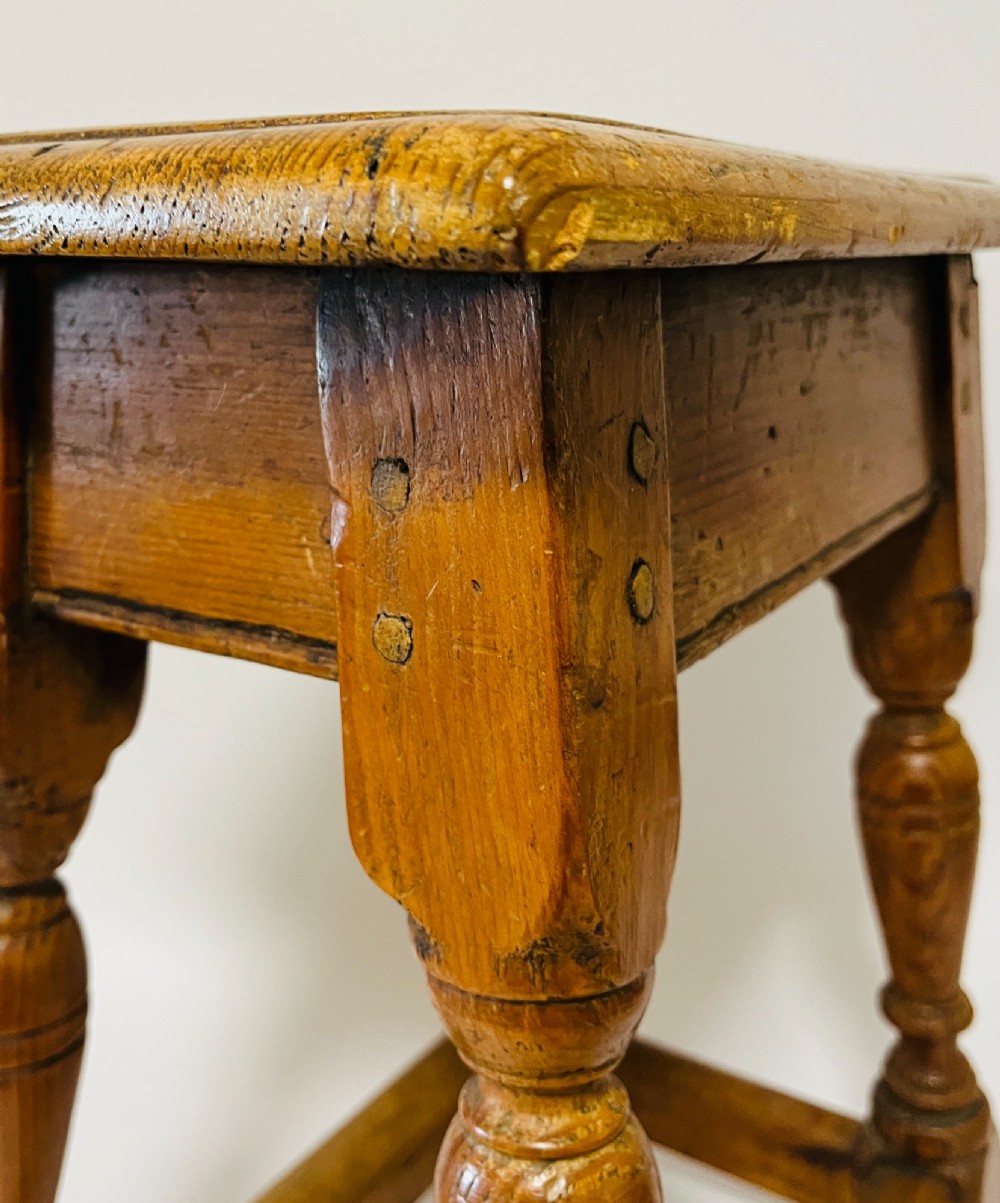 A low rectangular antique pine joint stool with turned legs, base stretchers, and visible wooden dowel construction. View VIII