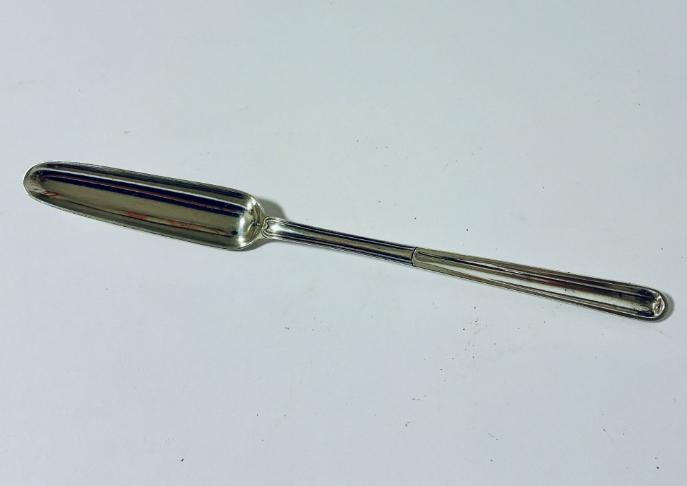 An elongated Georgian silver marrow scoop featuring a deep concave channel end tapering along a linear stem.