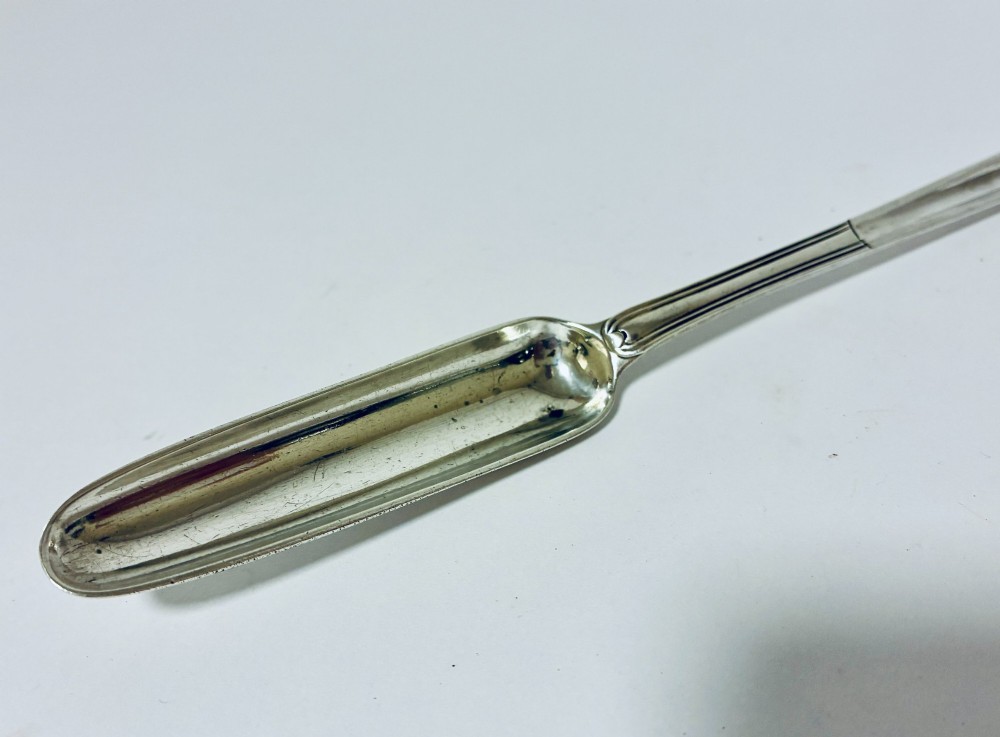 An elongated Georgian silver marrow scoop featuring a deep concave channel end tapering along a linear stem. View IV