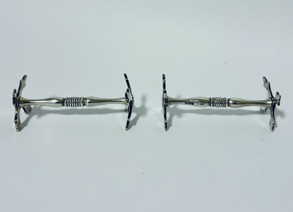 A pair of antique sterling silver knife rests with ribbed central bars and star-shaped pierced ends. View IV