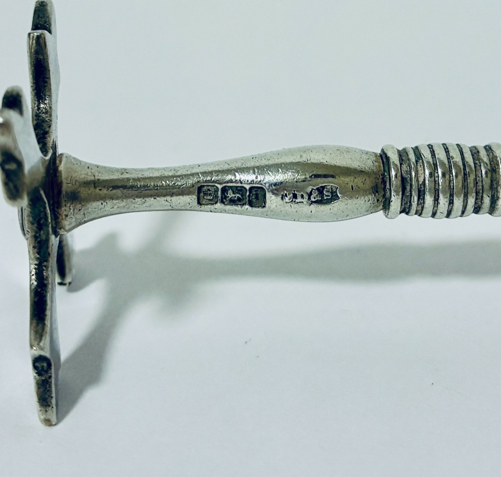 A pair of antique sterling silver knife rests with ribbed central bars and star-shaped pierced ends. View V