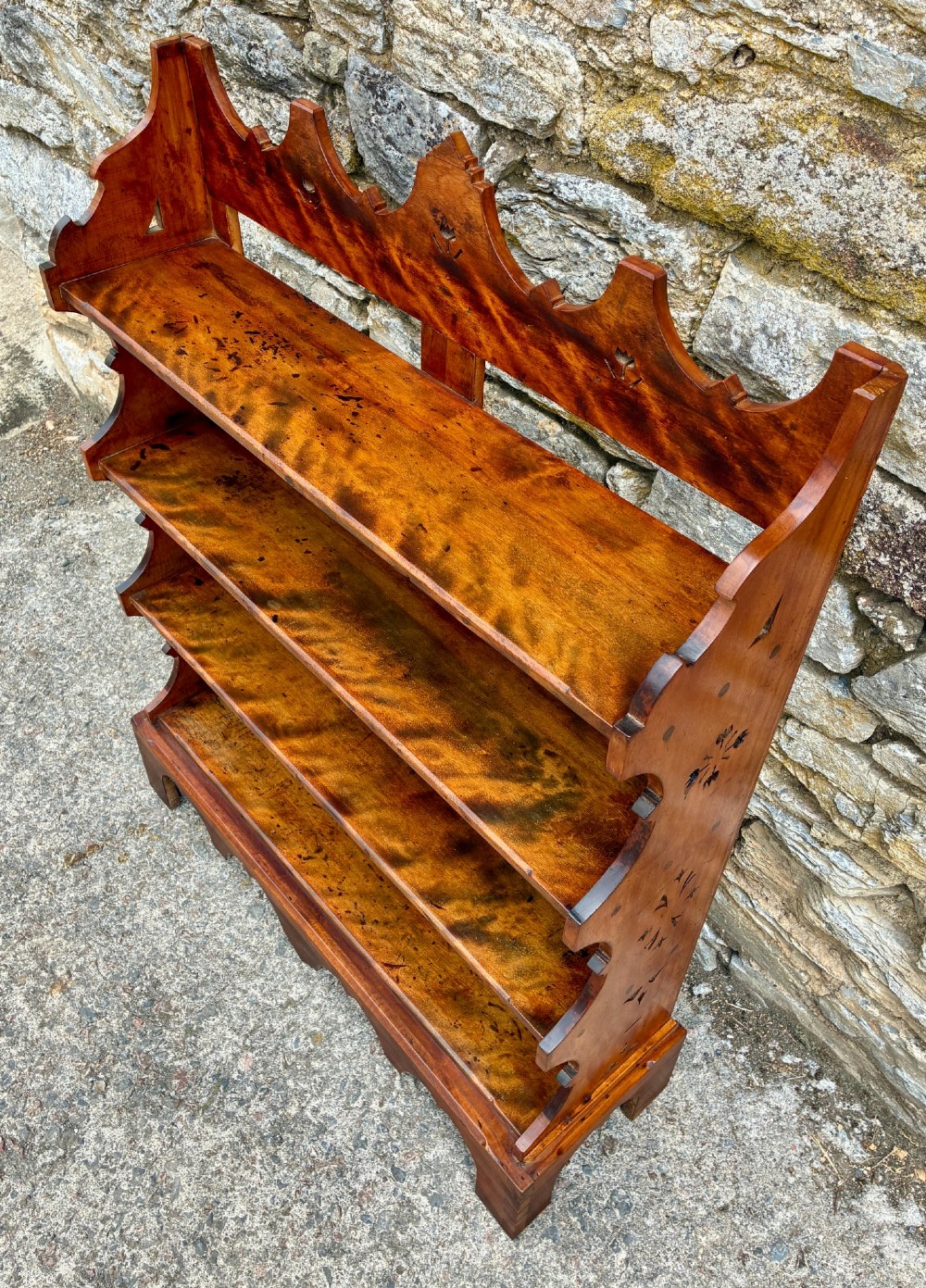 An Arts and Crafts satinwood open bookcase featuring four tiered shelves with a scalloped top gallery, shaped sides, and decorative pierced cut-outs. View IV